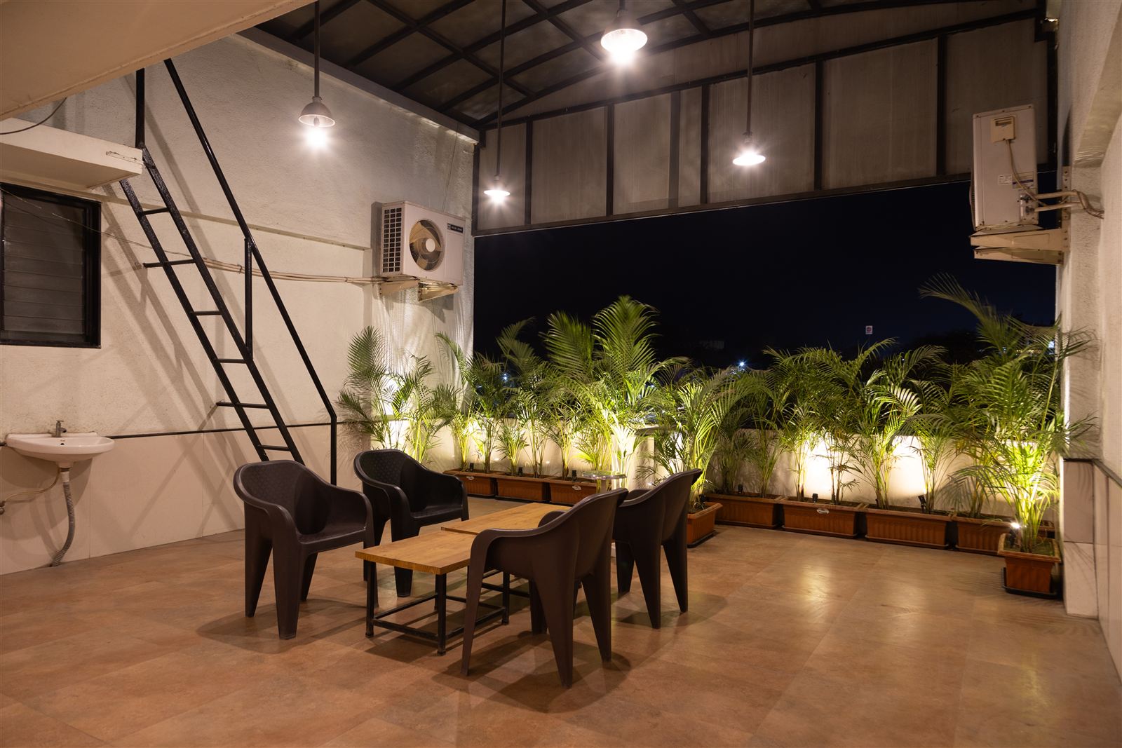Rooftop sit-out at night with plants